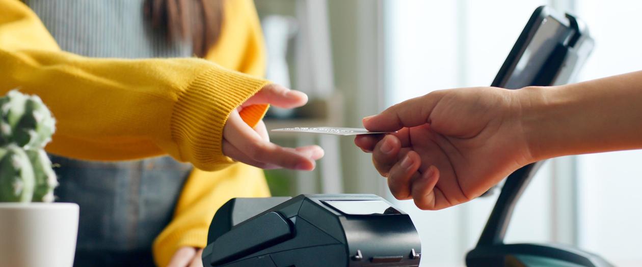 closeup of a person using a credit card to checkout